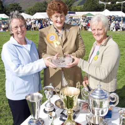 President's Trophy..Show president Isabel Birkett presents the presidents trophy to joint winners of most points overall in the industrial tent to Susan Pollock of Ivegill and Nancy Todhunter of Greystoke.